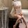 A woman sits elegantly wearing a sheer cherry blossom lace qipao sleepwear set, featuring vintage-inspired design elements an...
