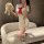 A person poses on a couch wearing a cherry blossom-themed high-slit student uniform set from cherry blossom lingerie, featuri...