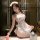 Woman wearing cherry lace maid costume with backless apron, cheeky cut-outs, and sheer trim.