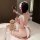 Woman wearing cherry romance lingerie dress, a sexy lace maid costume with bow details, sitting on bed holding heart mirror.