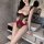 Woman wearing red and black cherry romance lingerie set with sheer bodysuit in modern bathroom setting.