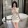 A woman poses elegantly in a cream cherry romance sexy lingerie set, featuring a slim-fit open-crotch uniform style cheongsam...