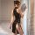 Woman in black cherry temptation qipao lingerie with side ties and high slit, holding a fan by a window.