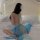 Woman wearing sheer blue chiffon chinese-style doudou bralette with matching skirt, back view on bed.