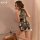 A woman poses elegantly wearing a black floral chinese-inspired halter dress, perfect for festive occasions. the plus-size ha...