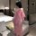 A woman stands facing away from the camera, wearing an elegant pink cherry blossom design original chinese-inspired lingerie ...