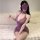 Woman wearing purple sheer chinese-style qipao lingerie dress with floral embroidery and bodycon fit, sitting on fluffy white...