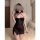 A woman poses in a black sheer mesh lace halter dress featuring a side slit, creating a seductive look. the dress has delicat...