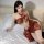 A woman poses on a bed wearing a chinese silk qipao lingerie set, featuring high-slit sheer fabric and ancient dunhuang style...