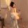 A woman poses elegantly wearing a sheer, translucent chinese-inspired sleepwear set with delicate embroidery details. the out...
