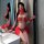 A woman poses in a mirror wearing a vibrant red chinese new year-themed exotic dance costume, featuring intricate designs and...