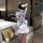A woman stands facing away from the camera, wearing a white chinese new year-themed sexy lingerie dress inspired by a red qip...