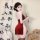 A woman poses elegantly in a red chinese new year silk velvet cheongsam lingerie set, featuring a lace-up high-waist slit dre...