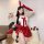 A woman poses wearing a festive christmas bunny girl costume, featuring a red plush rabbit outfit with matching gloves and he...