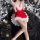 A woman poses in a festive christmas-themed outfit, featuring a red mini skirt with white fur trim and matching lace lingerie...