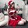 A woman poses in a festive christmas-themed outfit, featuring a red velvet halter bra dress with butterfly bows and a mini sk...
