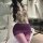 Woman wearing chu rui deep v-neck lace bodycon dress with purple skirt, posing seductively in a modern bathroom setting.