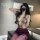 Woman wearing chu rui deep v-neck lace bodycon dress with purple skirt and thigh-high stockings in modern room.