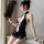 Woman in black backless cheongsam costume with white trim, holding feather fan. classic mandarin collar maid outfit with shor...
