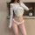Elegant white lace cross-back thong bikini with bow detail, perfect for a sensual and chic look.