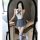 Woman in mirror wearing backless jk-style bodysuit with bow, pleated skirt, and striped knee-high socks.