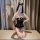Woman wearing black lace lingerie set with bow, posing on bed in romantic nightwear outfit for couples.