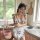 A woman wears a cow print maid costume, featuring bunny ears and a playful apron design, perfect for cosplay with a cute and ...