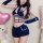 Woman modeling cute bunny girl costume set with navy split short shorts, crop top, and arm sleeves for sexy rabbit officer ro...