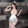 Woman wearing cute cow maid costume set with horns, spotted lingerie top, apron skirt, and lace thigh-highs for sexy role pla...