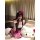 A person wearing a cute hello kitty maid costume set, featuring a pink and white checkered skirt, black apron, and cat ears w...