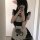 A person wearing a cute maid dress featuring a black and white checkered apron with cat paw designs, perfect for cosplay or a...