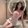 Woman in white nurse-themed lingerie set with red accents, posing seductively on bathroom counter.