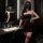 Woman modeling dark romance lace mesh cheongsam set with rose-embellished halter corset and high-waisted thong bodysuit in bl...