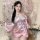 A woman elegantly poses holding an ornate parasol, wearing a pink anime-inspired kimono with floral patterns and a large bow ...