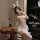 Woman in white lace bunny lingerie with ears, garter, and mask—seductive dominatrix-inspired sleepwear set.