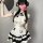 A woman wears a cute panda-themed domoira chinese-style maid outfit, featuring a white dress with black accents and ruffled s...