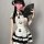 A woman wears a cute panda-themed domoira chinese-style maid outfit, featuring a white dress with black accents and ruffles, ...