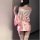 A woman models the domoira temptation lingerie set, featuring a pink floral kimono-style design with a deep v neckline and bo...