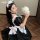 A woman wearing a black and white maid costume holding a plush bear, perfect for cosplay or role play.