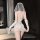 Woman wearing dreamy bridal lingerie set with sheer lace, mesh skirt, veil, and gloves — romantic wedding underwear for women...