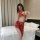 Woman modeling red dunhuang flying apsara lingerie set with sheer mesh, gold trim, and matching face veil in bedroom.