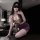 Woman in elegant deep v-neck lace lingerie set, kneeling on desk with blindfold, wearing tight-fit purple skirt and garter be...