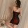 Woman wearing elegant satin slip dress with lace details, posing in romantic boudoir setting with candles and flowers.