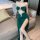 Woman wearing emerald green lace wrap dress with high slit and backless design, perfect for nightclub or lingerie set.