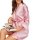 A woman wearing a pink striped satin robe, holding an open magazine, exuding comfort and style.