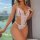 Woman wearing white european-american lace bodysuit with mesh details, backless design, and bow accents by window.