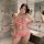 Woman in pink lace lingerie set with bow detail, posing in marble bathroom. european & american style sleepwear outfit.