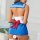 Woman wearing a blue and white sailor-style lingerie set with a red bow, featuring a short skirt and open back design.