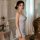 Woman wearing blue floral european-style lace sheer slip dress, elegant mesh camisole nightgown with ruffles and heart earrin...