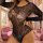 Woman wearing a european sexy lace bodysuit with sheer mesh and floral embroidery in a luxurious pink room.